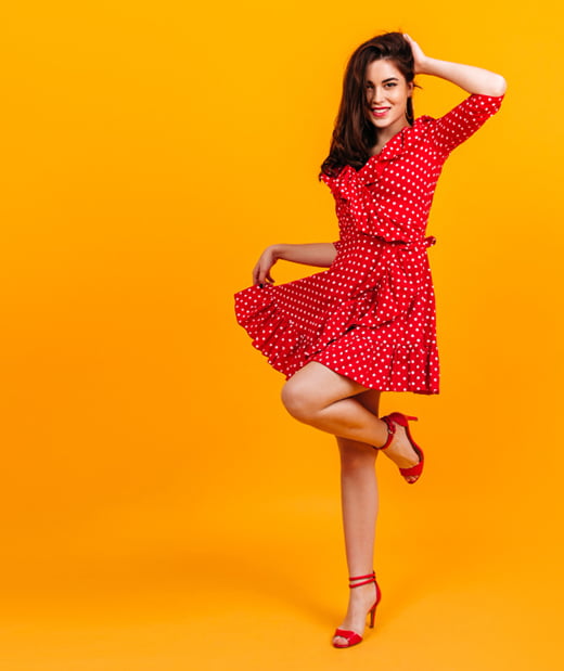charming-slim-brunette-woman-pin-up-dress-coquettishly-raised-her-leg-isolated-wall